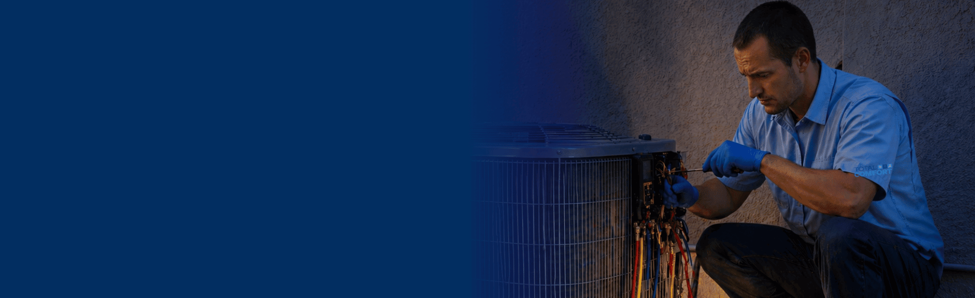 Total Comfort technician repairing AC at night